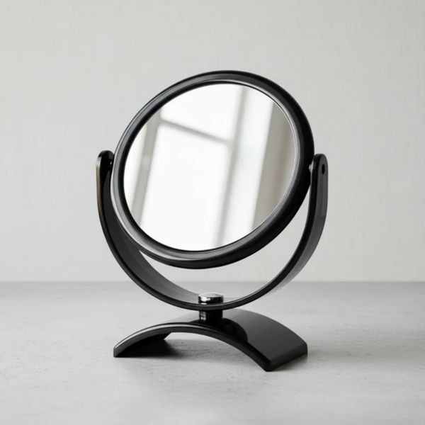 Espelho de aumento para maquiagem, redondo, de mesa, acabamento preto, em ambiente interno neutro, foco no espelho central e na base.