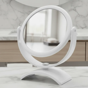 Espelho de aumento para maquiagem, redondo, de mesa, acabamento branco, sobre bancada de banheiro em mármore, foco no espelho central.
