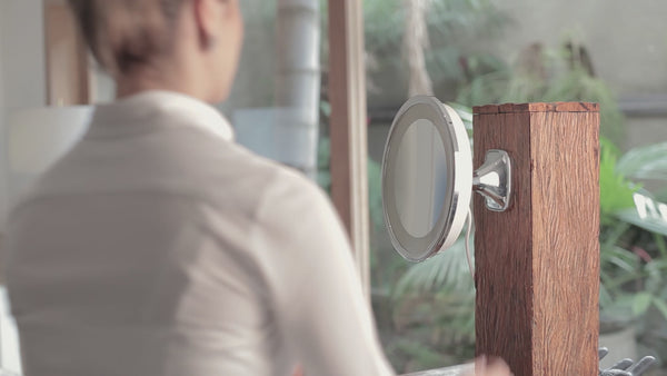 Espelho com LED para maquiagem VISAGE LUX instalado na parede e sendo utilizado por uma modelo