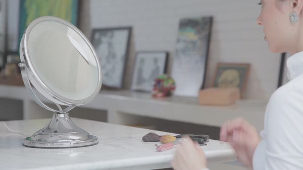 Espelho com LED para maquiagem CLASSIQUE LUX sendo utilizado por uma modelo